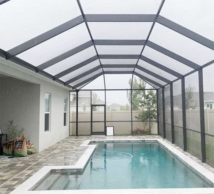 A photo of a new pool enclosure installation with a view of the pool and surrounding landscaping