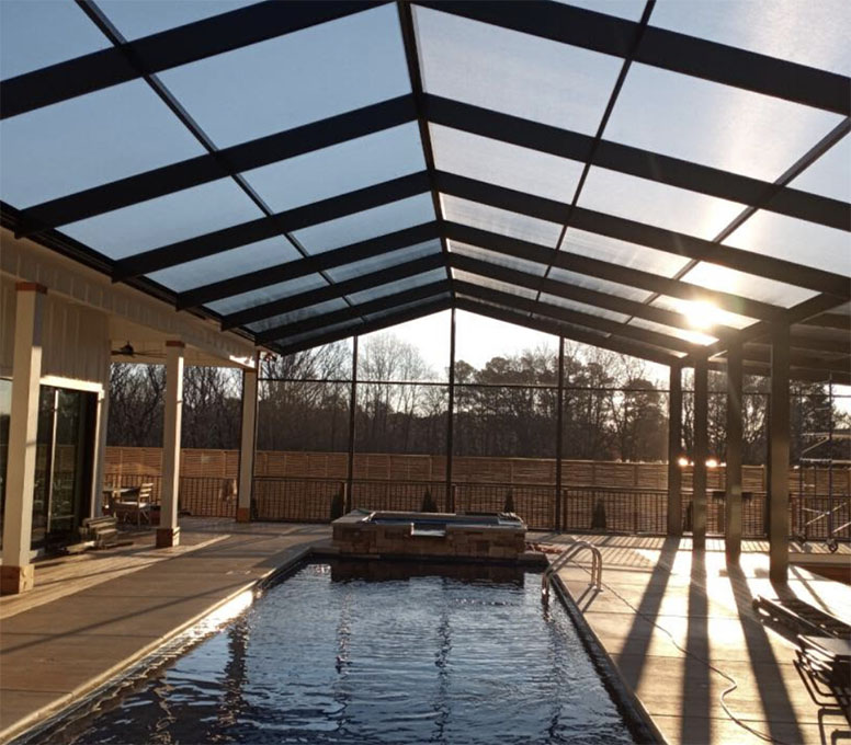 A pool enclosure renovation in progress, with workers installing new screens and updating the space